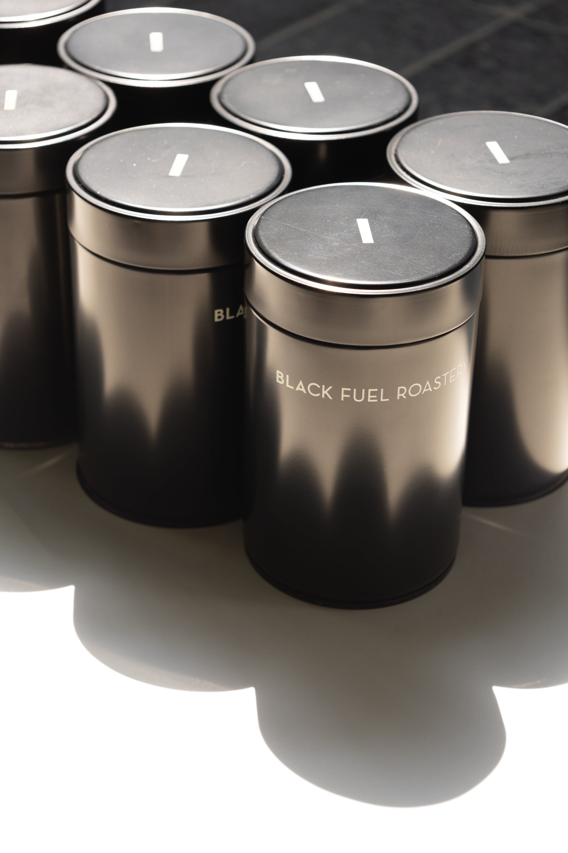 Set of black cylindrical containers with 'Black Fuel Roast' branding on a white base.